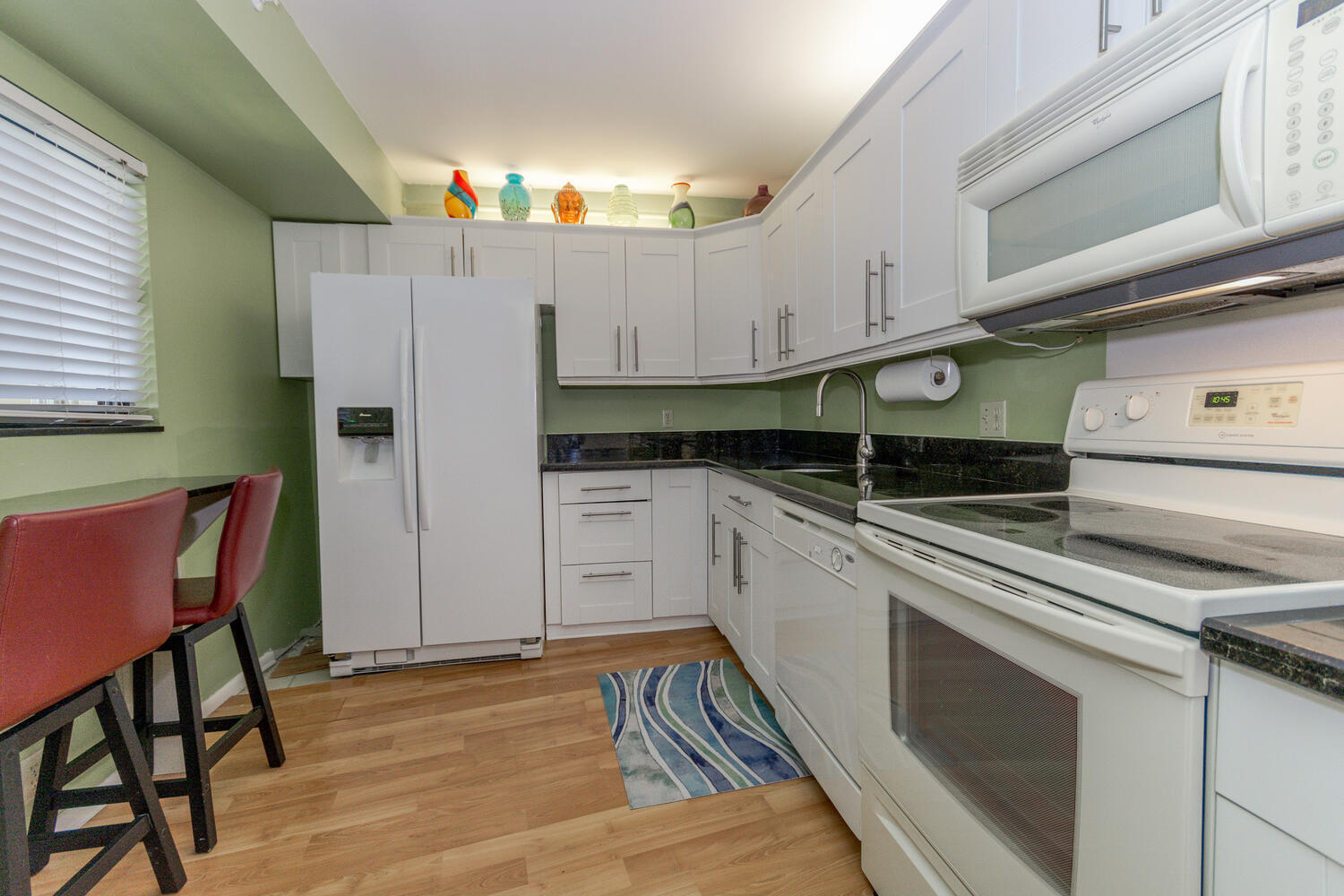 400 Ocean Trail Way, Unit 1405 Jupiter, FL 33477 - Photo 14 of 41 a kitchen with granite countertop a stove a sink and a refrigerator