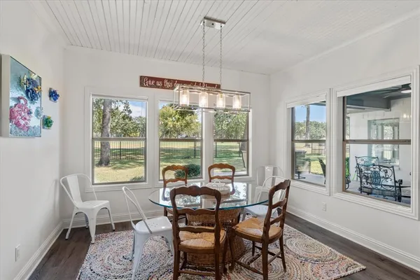 a dining room with furniture a chandelier and wooden floor