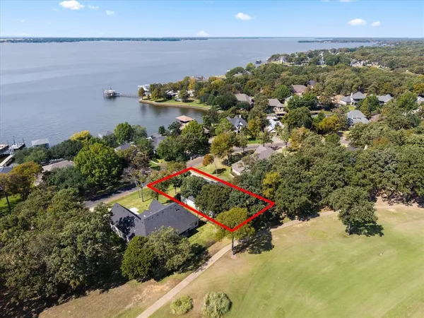 an aerial view of a house with a yard and lake view