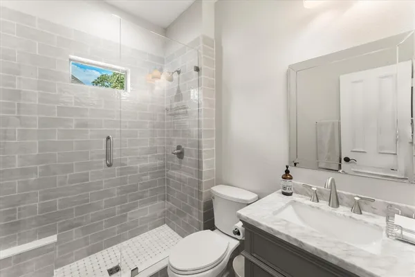 a bathroom with a sink a toilet and shower
