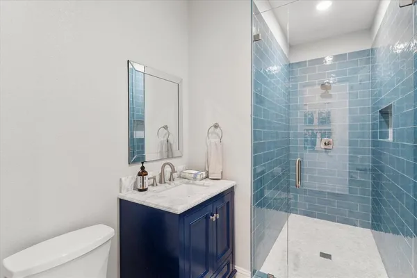 a bathroom with a sink a toilet and shower