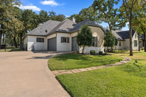 a front view of a house with a garden and trees