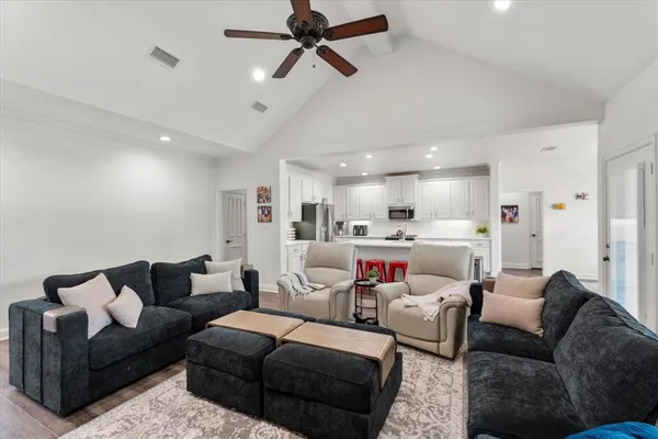 a living room with furniture kitchen view and a window