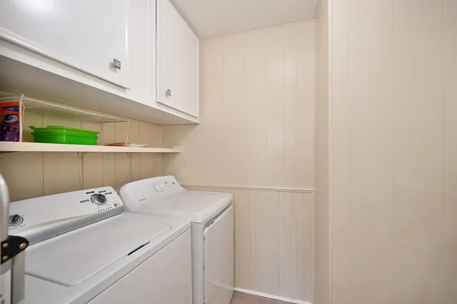 a kitchen with granite countertop a sink a stove a clock and cabinets