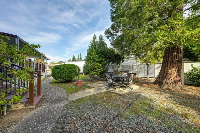 a backyard of a house with pool table and chairs