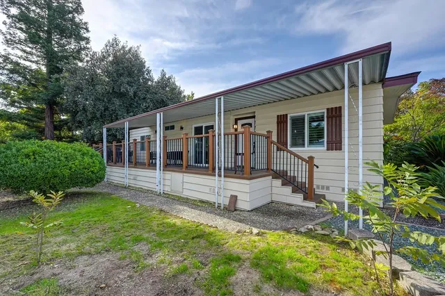 a view of a house with backyard and sitting area