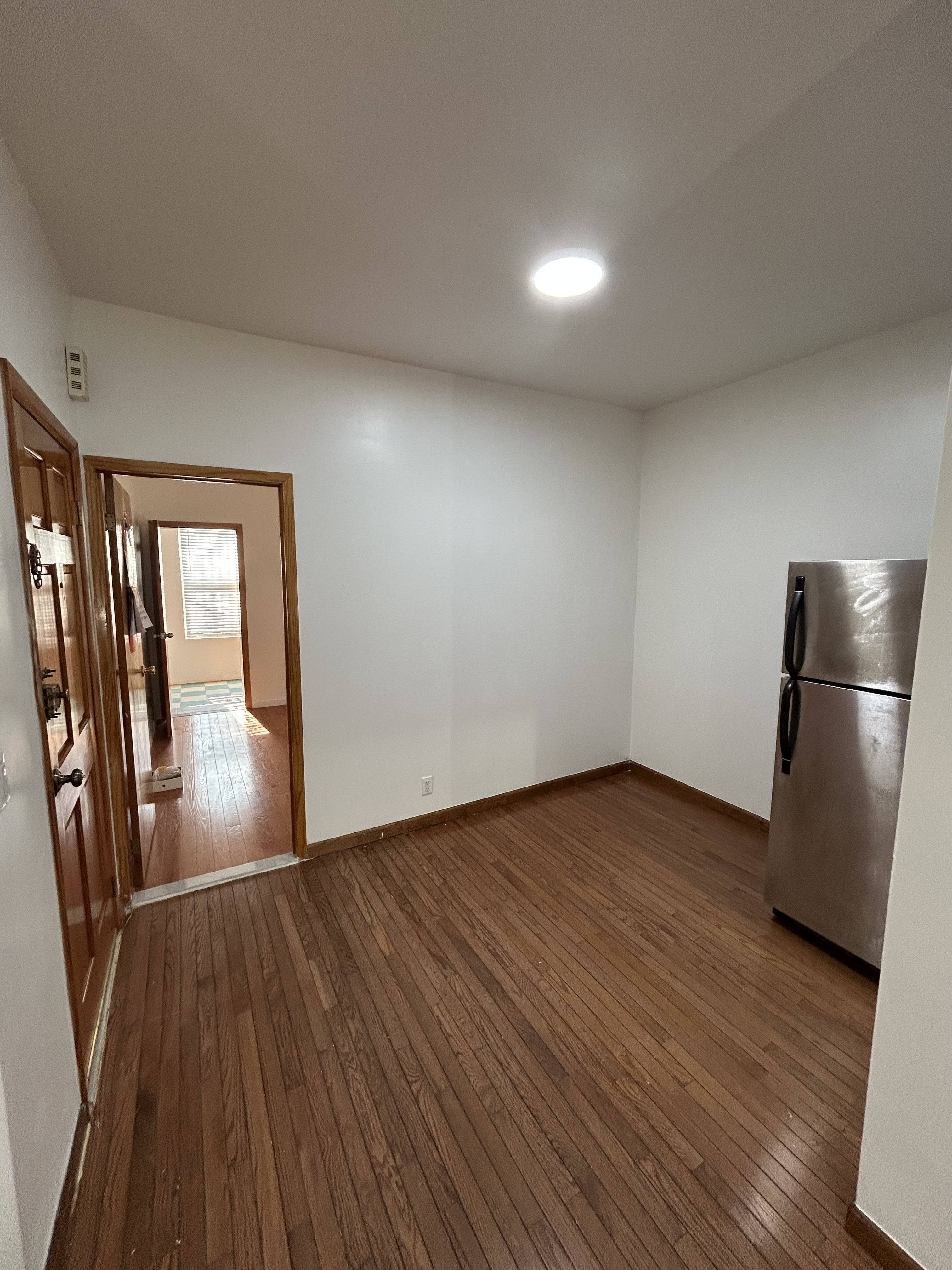 839 53rd Street, Unit 1 Brooklyn, NY 11220 - Photo 8 of 10 a view of an empty room with wooden floor and a window