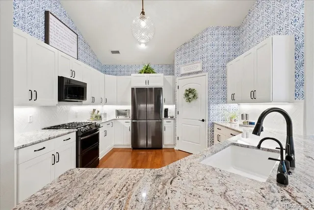a kitchen with stainless steel appliances kitchen island a refrigerator sink and wooden cabinets