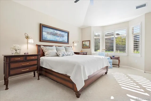 a bedroom with a bed and a painting on the wall