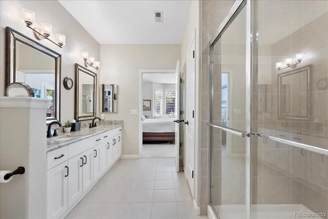 a bathroom with a double vanity sink mirror and shower