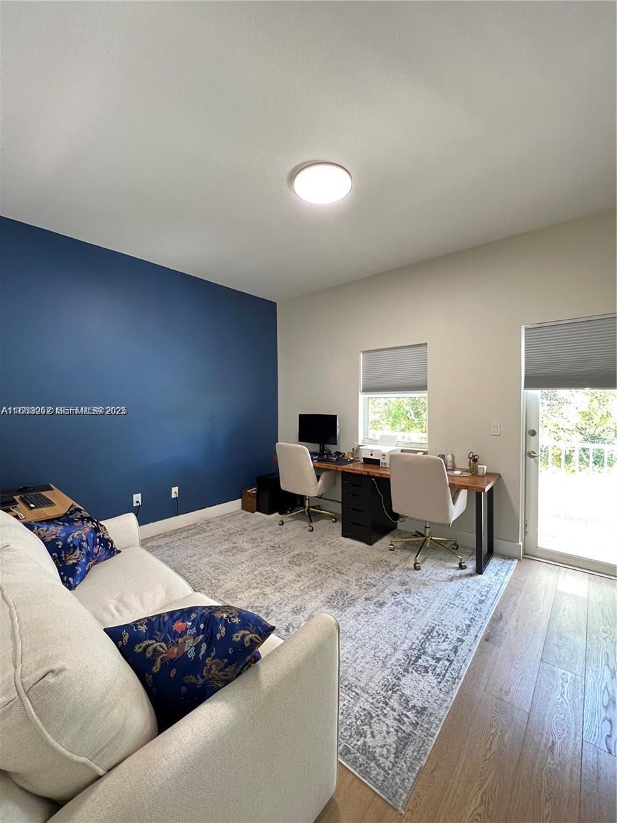 1043 Southwest 9th Court, Unit F1 Miami, FL 33130 - Photo 17 of 27 a living room with furniture large window and a wooden floor