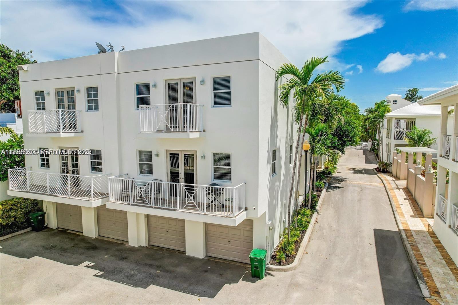 1043 Southwest 9th Court, Unit F1 Miami, FL 33130 - Photo 23 of 27 a view of a white house with many windows next to a yard