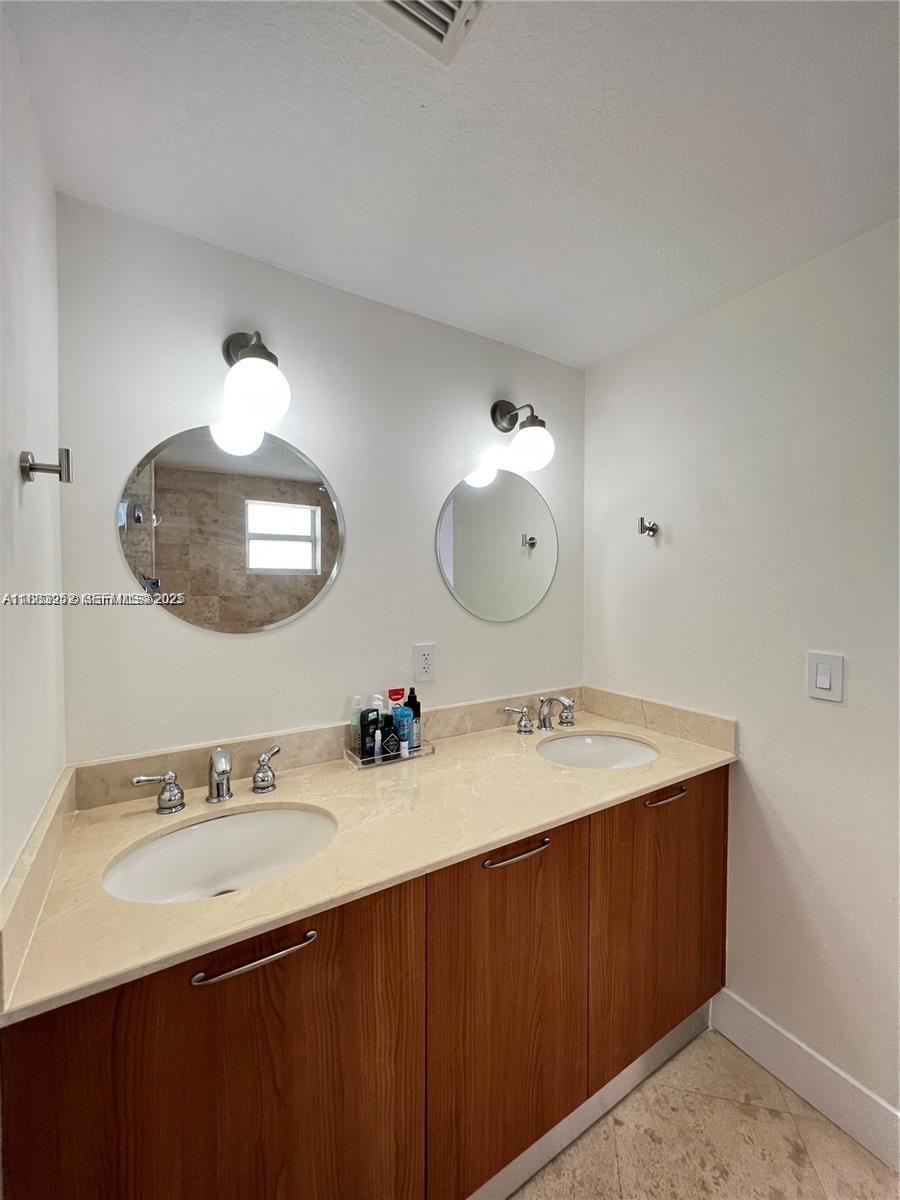 1043 Southwest 9th Court, Unit F1 Miami, FL 33130 - Photo 9 of 27 a bathroom with a granite countertop sink a large mirror and vanity