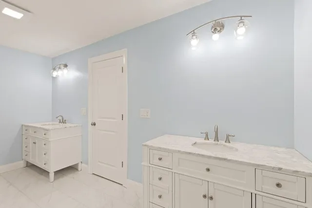 a bathroom with a double vanity sink and mirror