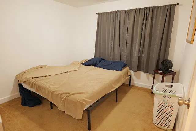 a bed sitting in a bedroom next to a cabinet