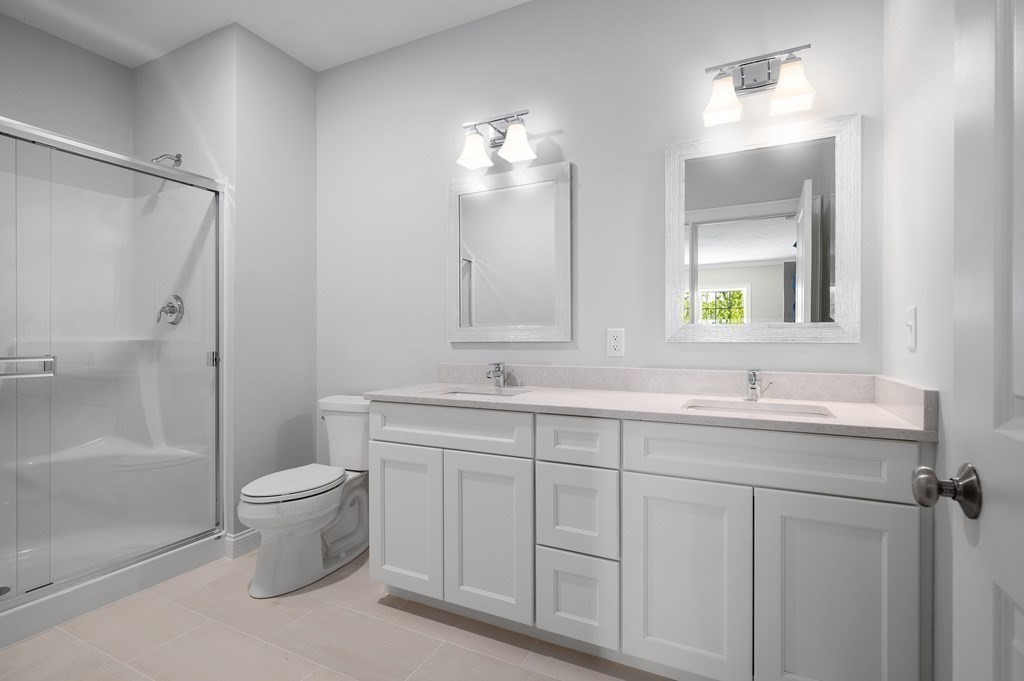 159 Rolling Rdg Drive, Unit 85 Northbridge, MA 01588 - Photo 15 of 25 a bathroom with a double vanity sink toilet and shower