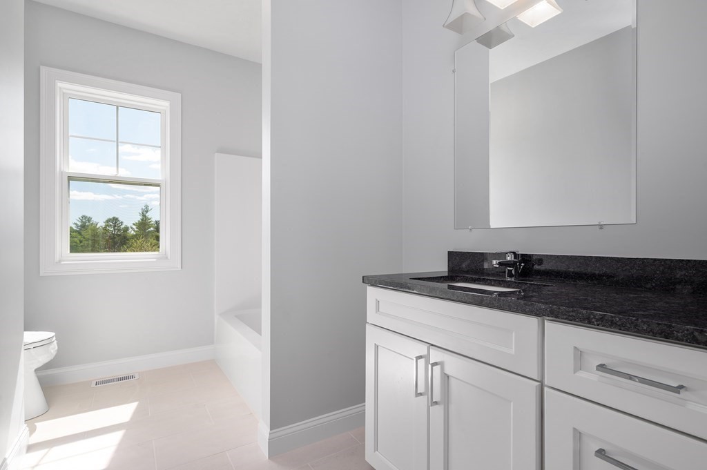 159 Rolling Rdg Drive, Unit 85 Northbridge, MA 01588 - Photo 18 of 25 a bathroom with a granite countertop sink a toilet and a window