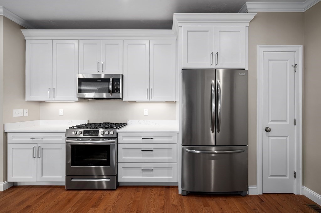 159 Rolling Rdg Drive, Unit 85 Northbridge, MA 01588 - Photo 9 of 25 a kitchen with refrigerator a stove and cabinets