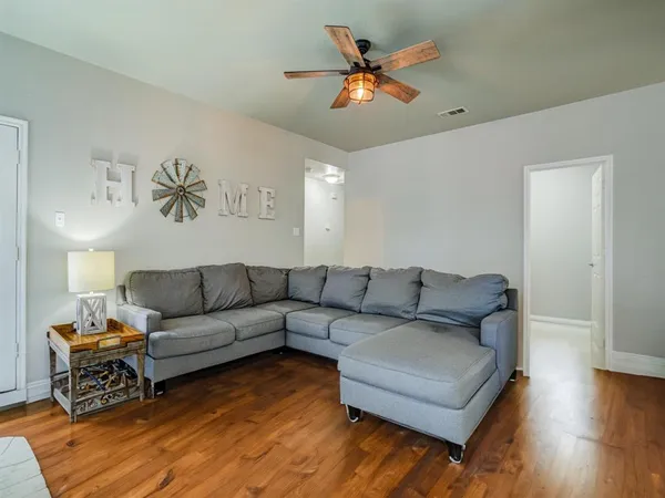 a living room with furniture and a wooden floor