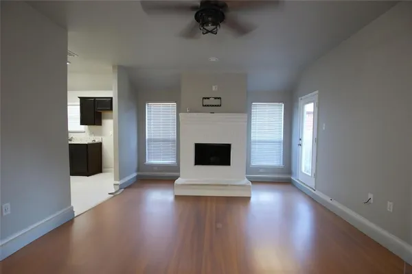 an empty room with a fireplace and wooden floor