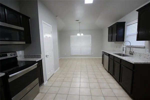 a kitchen with stainless steel appliances a sink stove and microwave