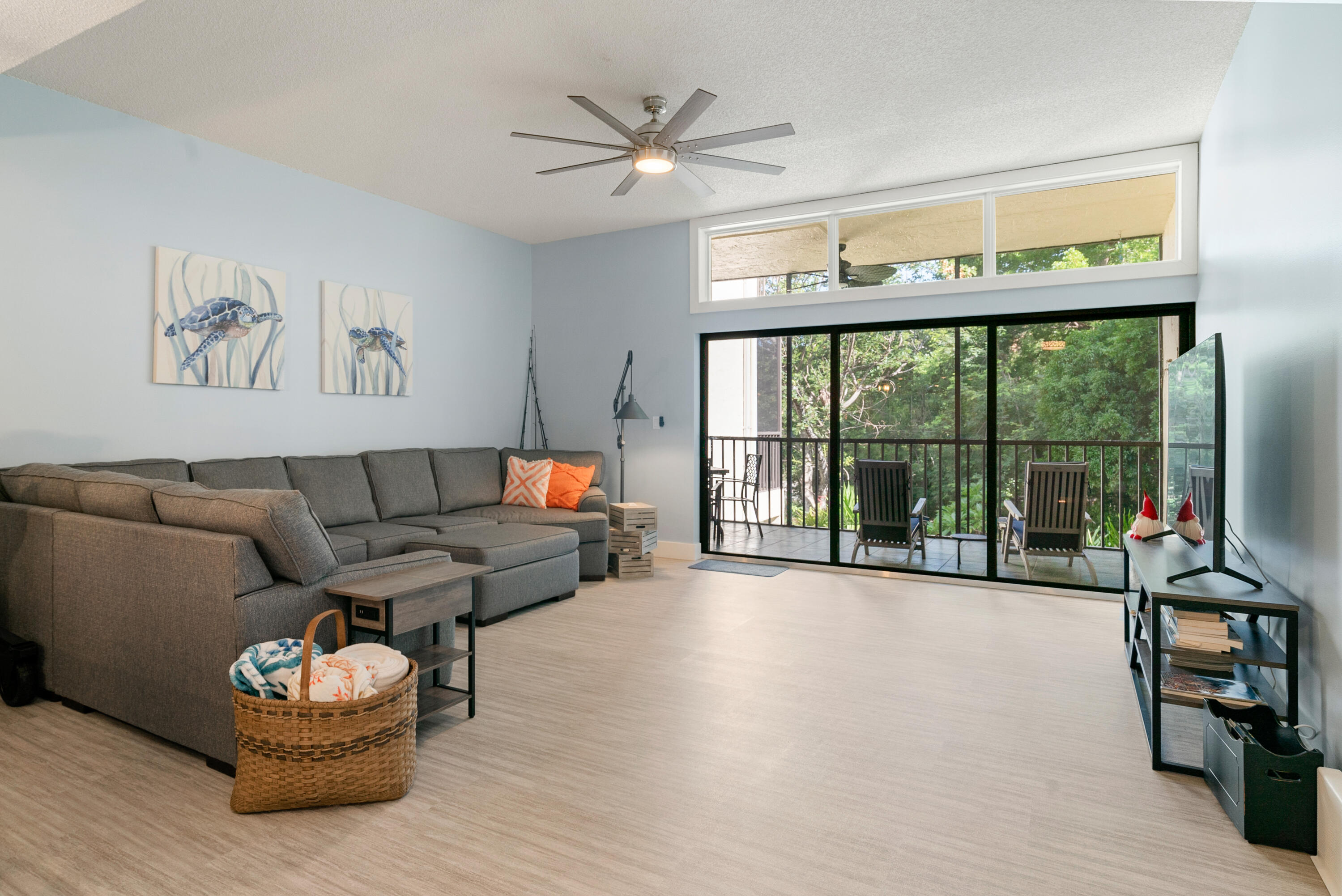 a living room with furniture and a large window with kitchen view