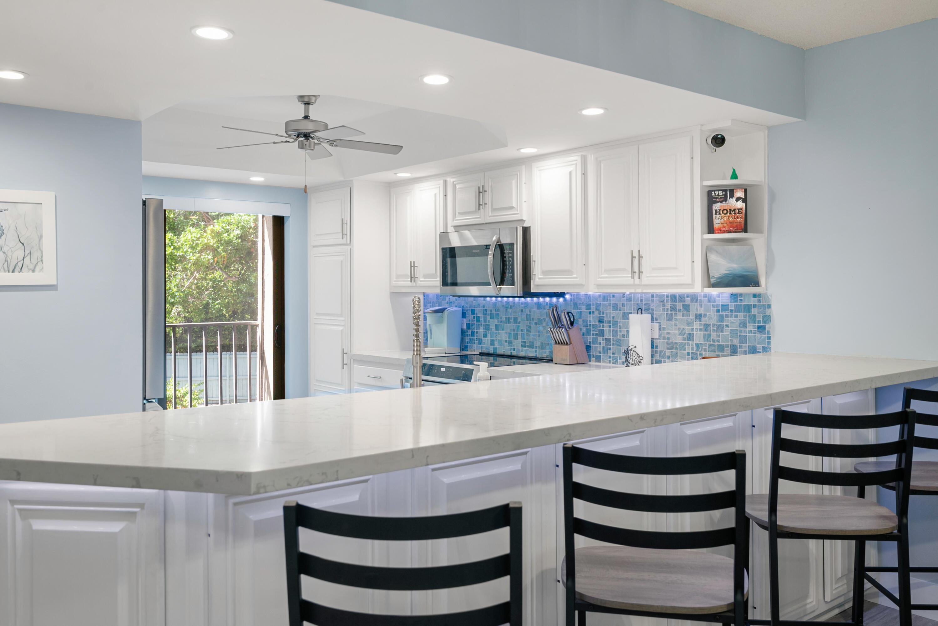 94220 Overseas Highway, Unit 5E Tavernier, FL 33037 - Photo 2 of 77 a kitchen with a table chairs refrigerator and microwave