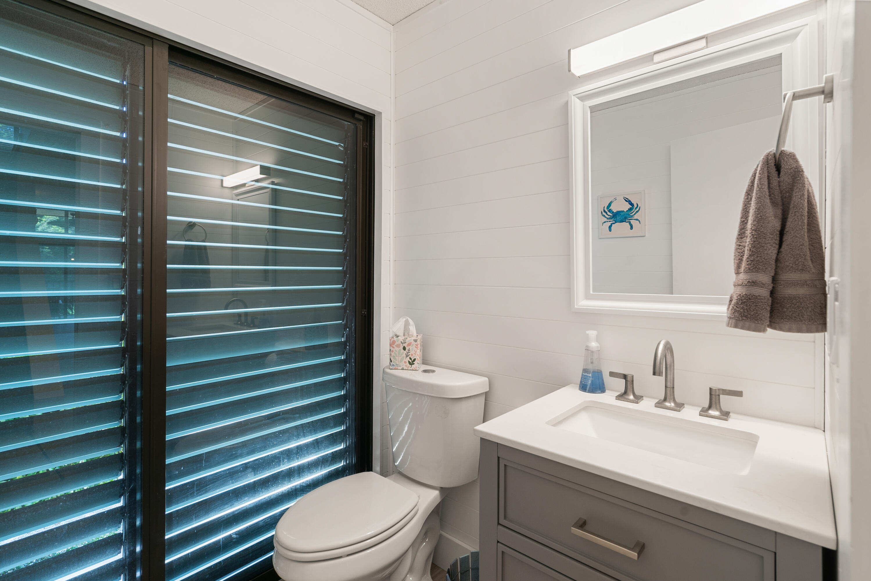 94220 Overseas Highway, Unit 5E Tavernier, FL 33037 - Photo 22 of 77 a bathroom with a sink a toilet and mirror