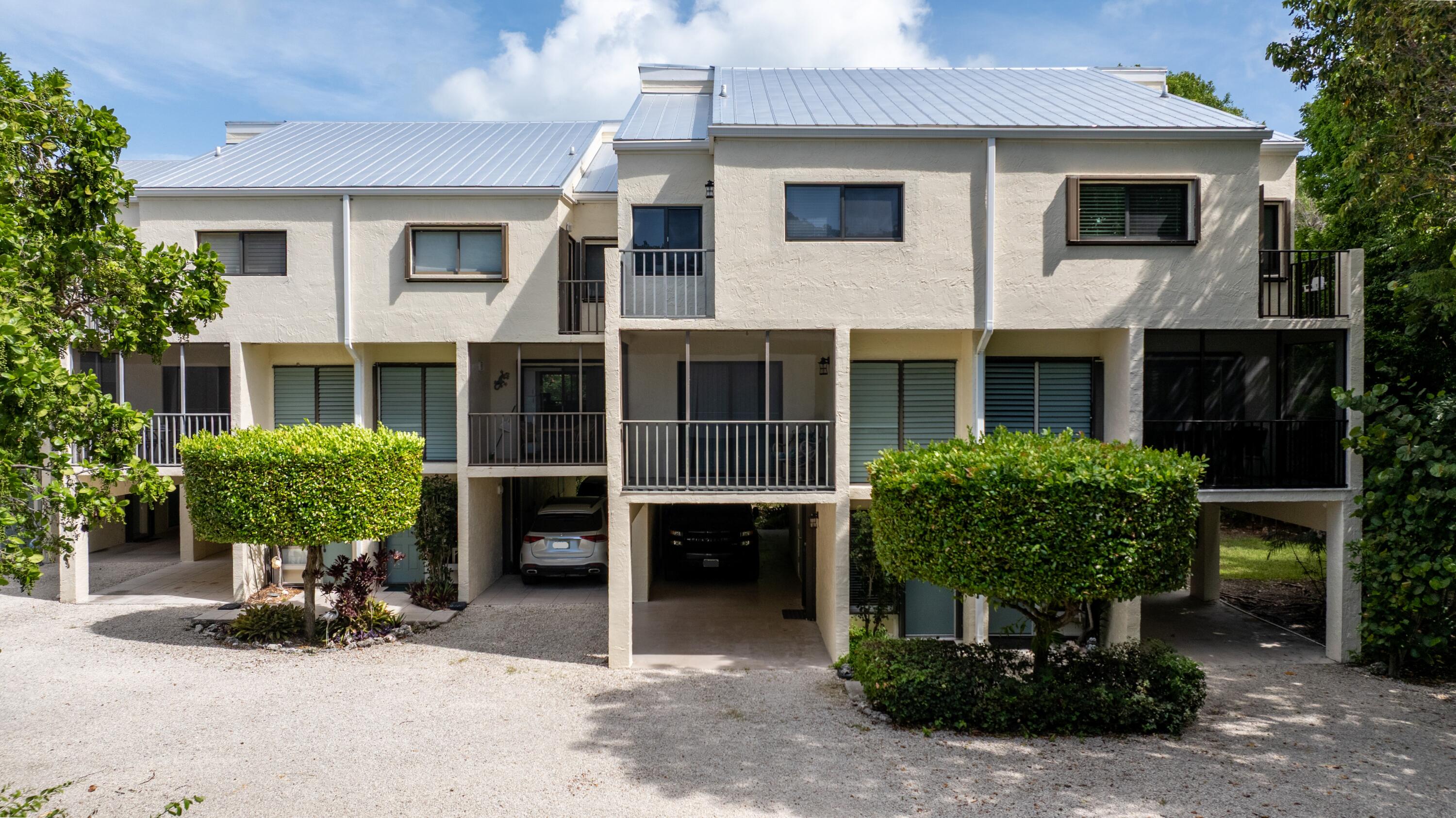 94220 Overseas Highway, Unit 5E Tavernier, FL 33037 - Photo 3 of 77 a front view of a house with a yard and glass windows