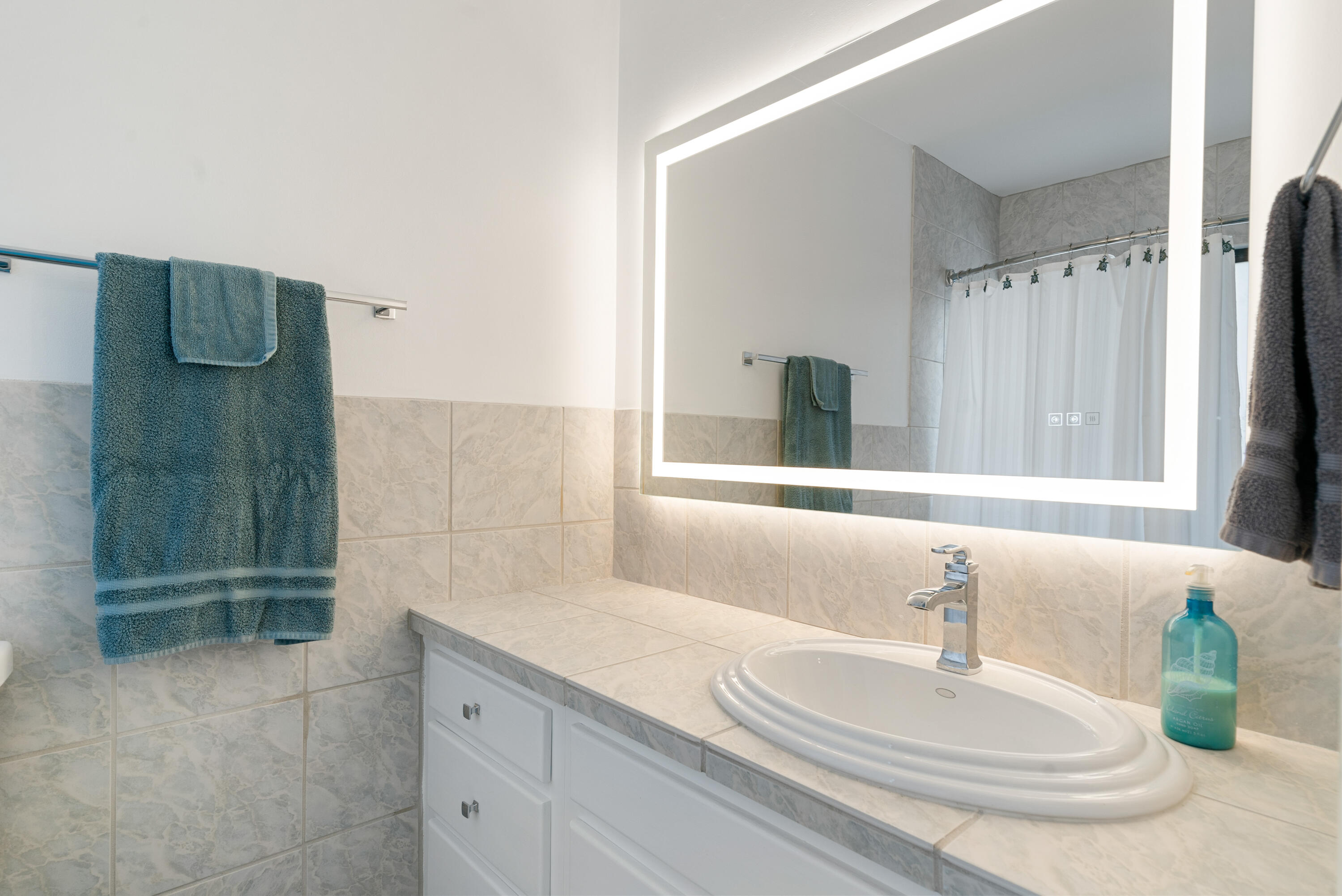 94220 Overseas Highway, Unit 5E Tavernier, FL 33037 - Photo 35 of 77 a bathroom with a granite countertop sink a mirror and shower