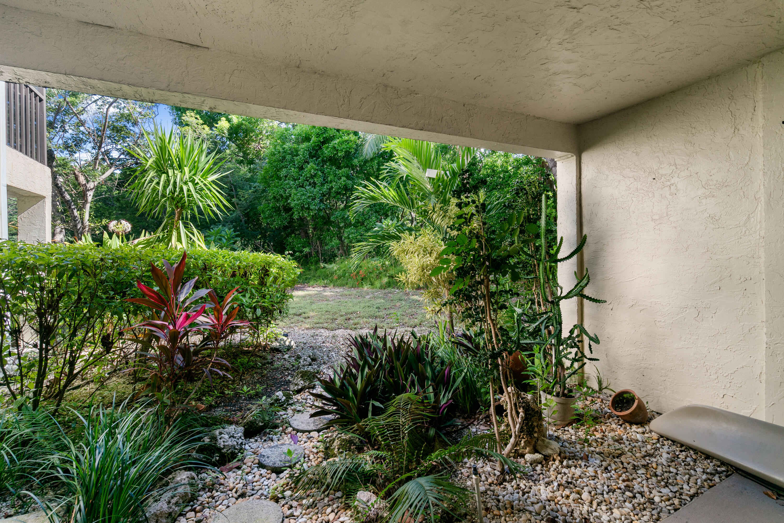 94220 Overseas Highway, Unit 5E Tavernier, FL 33037 - Photo 41 of 77 a view of a garden with plants and a bench