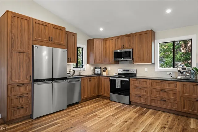 a kitchen with granite countertop a refrigerator stove and microwave