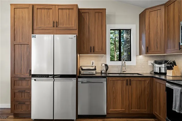 a kitchen with granite countertop a refrigerator sink and cabinets