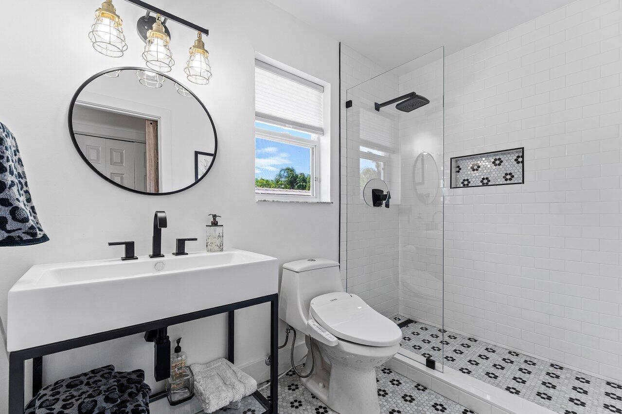 3395 Northwest 53rd Circle Boca Raton, FL 33496 - Photo 17 of 64 a bathroom with a sink a toilet and a mirror