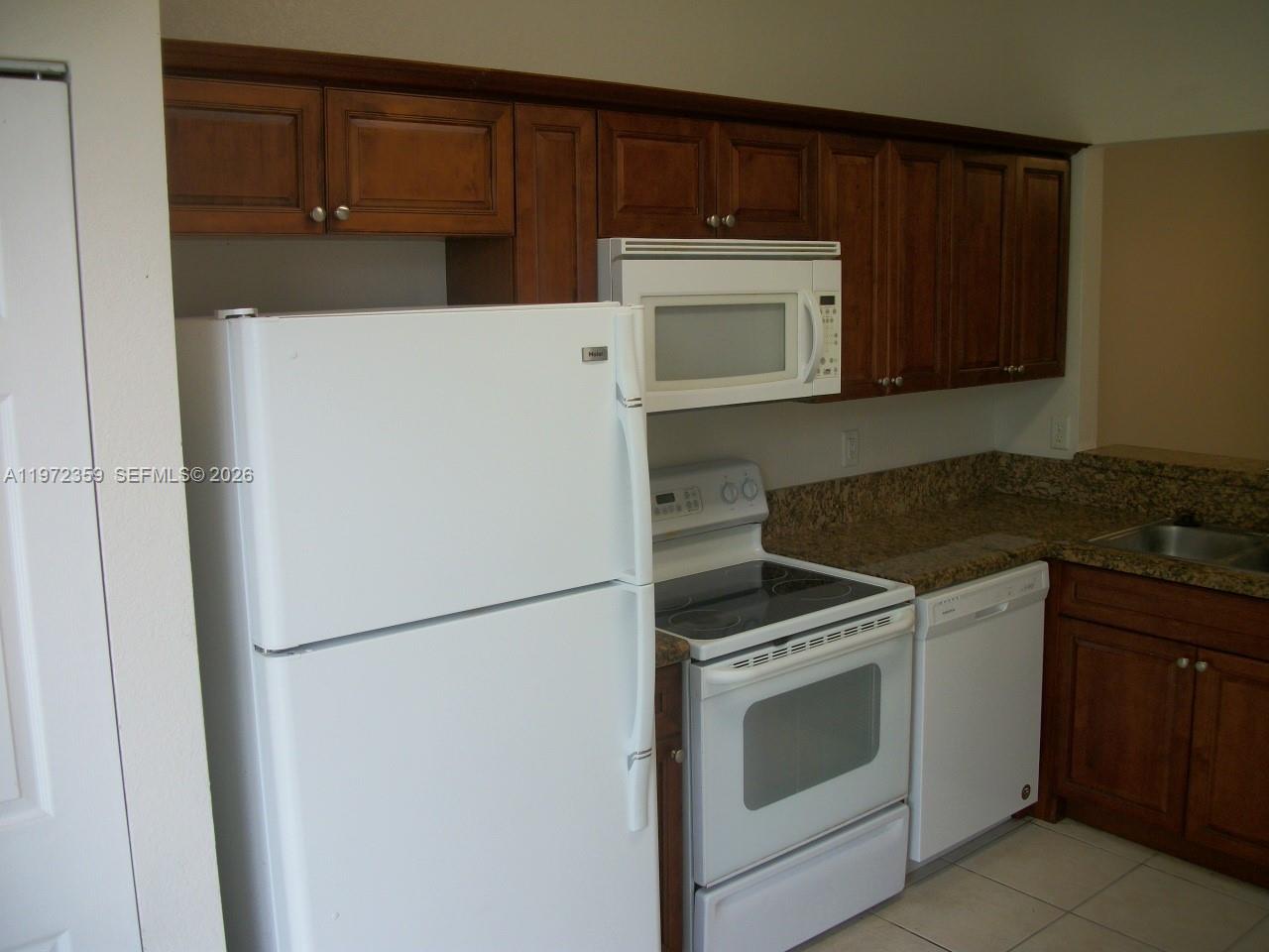 1596 Southwest 2nd Street Homestead, FL 33030 - Photo 12 of 42 a kitchen with a stove top oven and cabinets