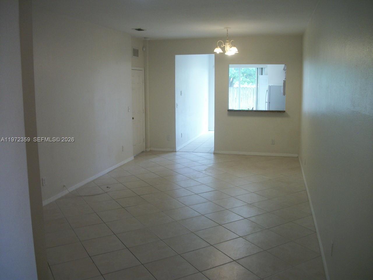 1596 Southwest 2nd Street Homestead, FL 33030 - Photo 16 of 42 a view of an empty room with window and chandelier fan