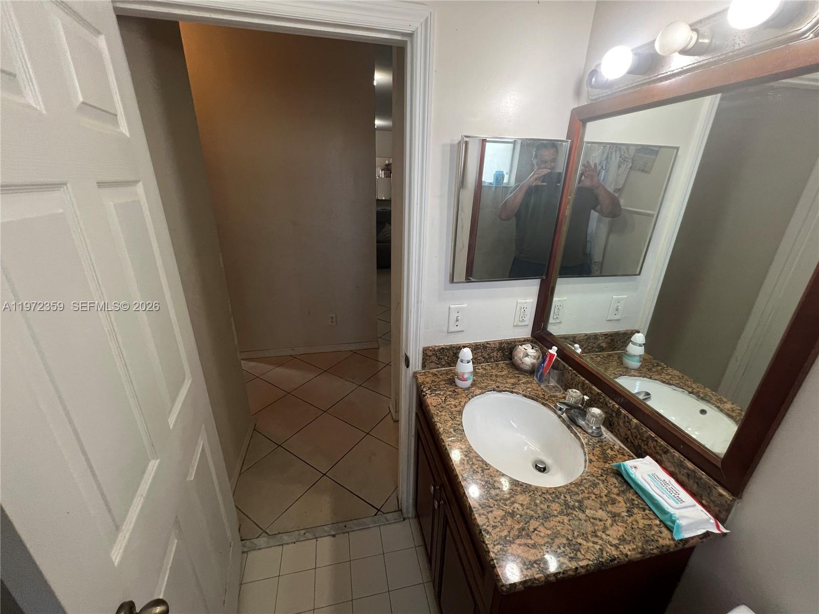 1596 Southwest 2nd Street Homestead, FL 33030 - Photo 19 of 42 a bathroom with a granite countertop sink a mirror and shower