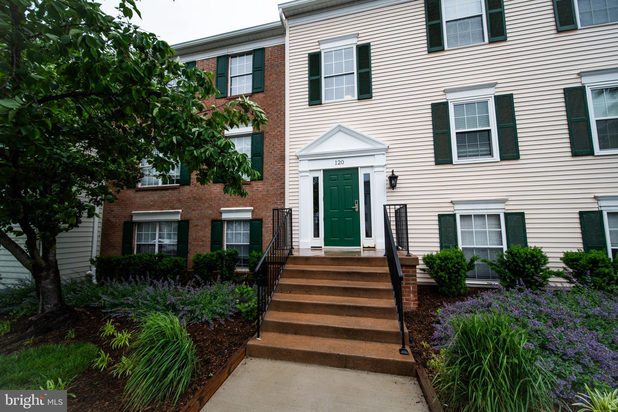 a front view of a house with plants and garden