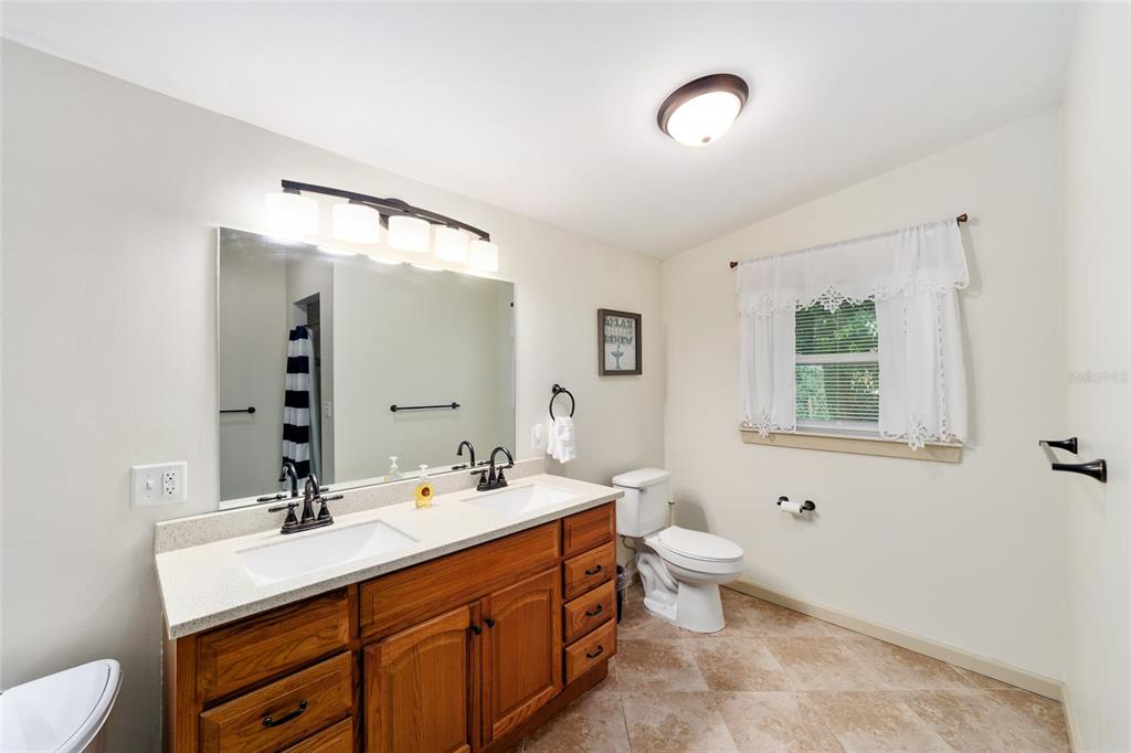 20693 Walnut Street Dunnellon, FL 34431 - Photo 32 of 51 a bathroom with a double vanity sink toilet and a mirror