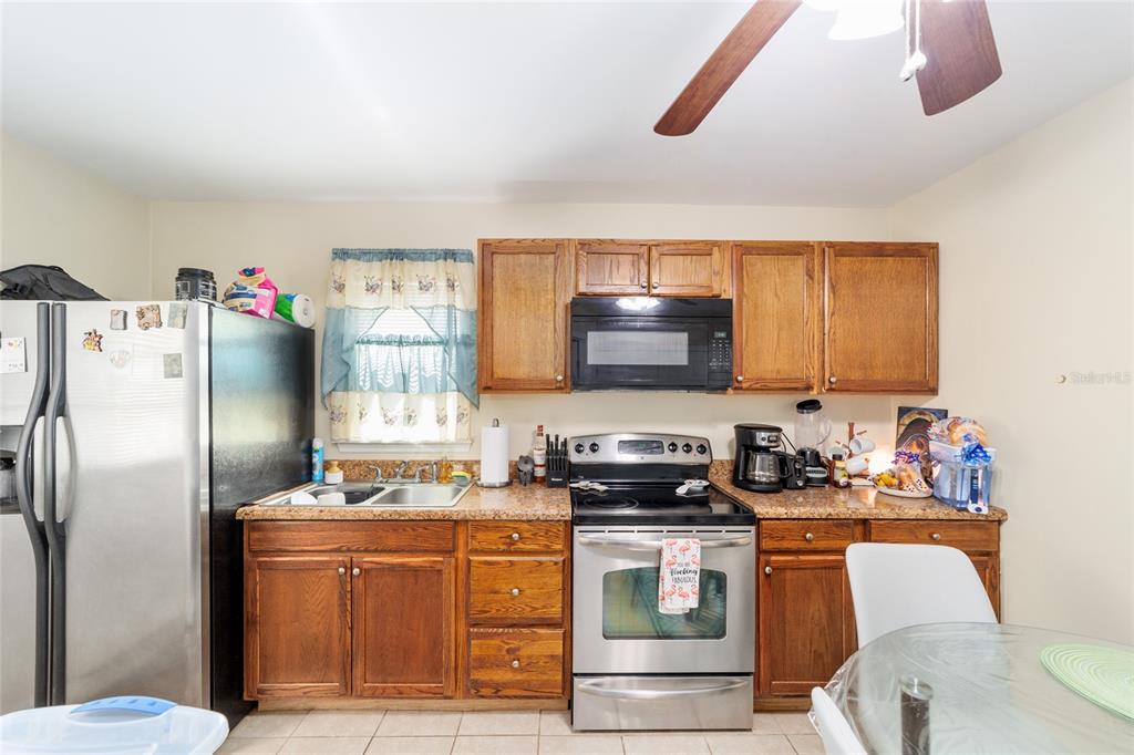 20693 Walnut Street Dunnellon, FL 34431 - Photo 43 of 51 a kitchen with stainless steel appliances a stove a sink dishwasher and a refrigerator with wooden floor