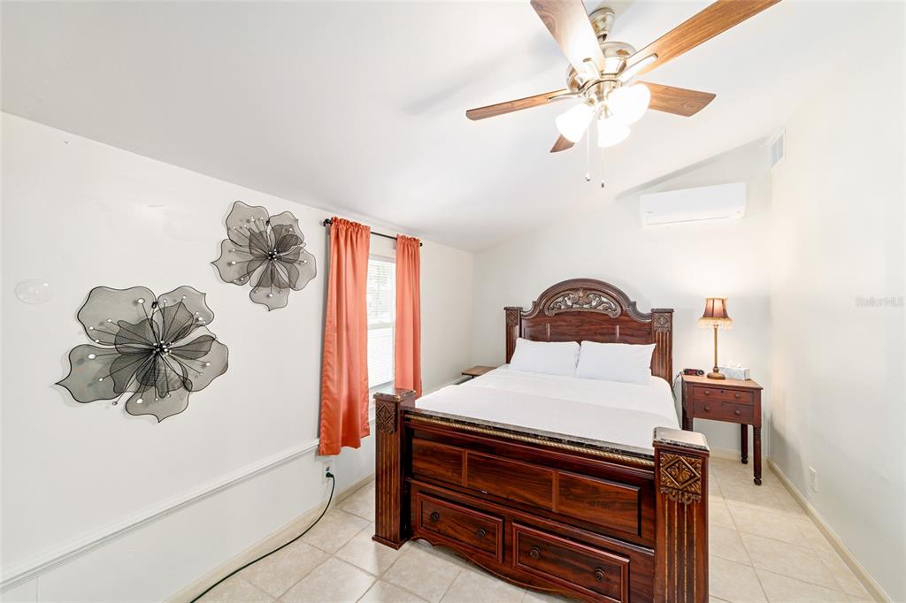 20693 Walnut Street Dunnellon, FL 34431 - Photo 9 of 51 a bedroom with a white bed and a chandelier