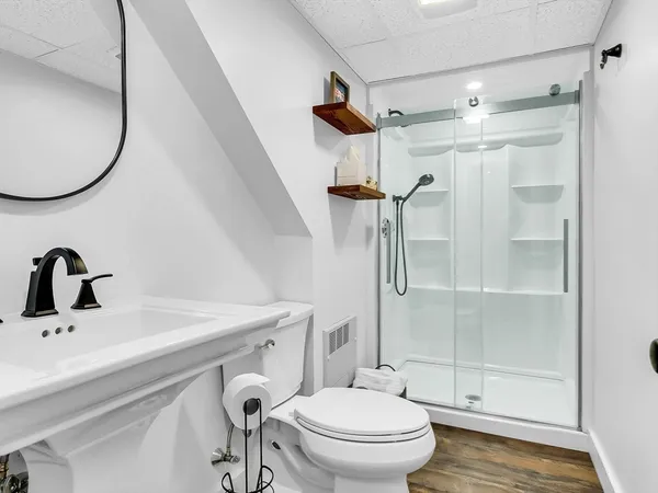 a bathroom with a sink a toilet and a mirror