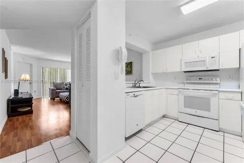 a kitchen with white cabinets and white appliances