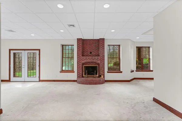 a view of an empty room with a fireplace and a window