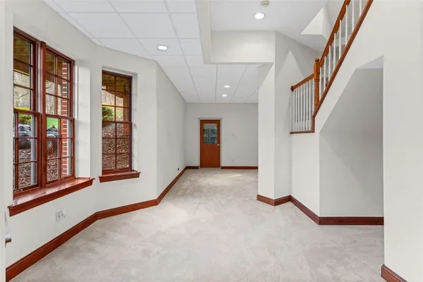 a view of an empty room with a fireplace and windows
