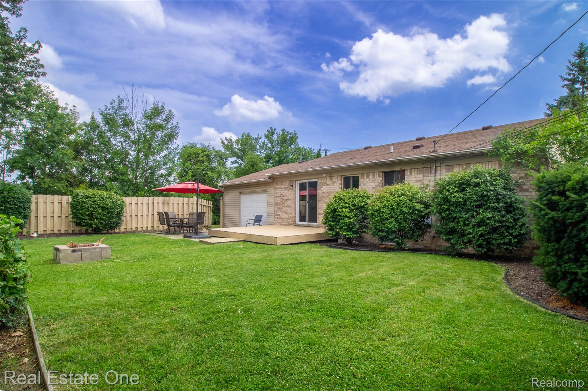 44220 Saltz Road Canton, MI 48187 - Photo 23 of 31 Expansive rear yard featuring a large lawn area, a wooden privacy fence, and mature perimeter trees