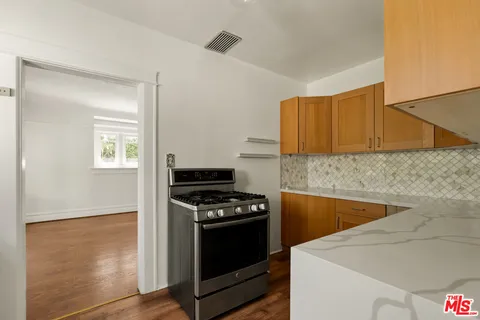 a kitchen with granite countertop a stove and a refrigerator