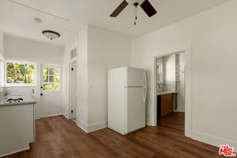 a view of a kitchen with a fridge wooden floor and a window