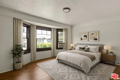 a bedroom with a large bed and a potted plant