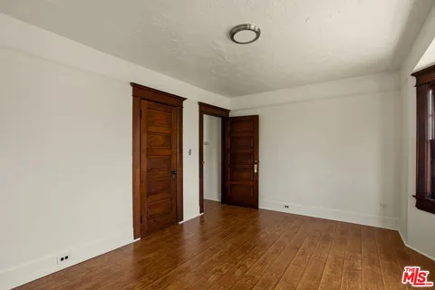 an empty room with wooden floor and closet